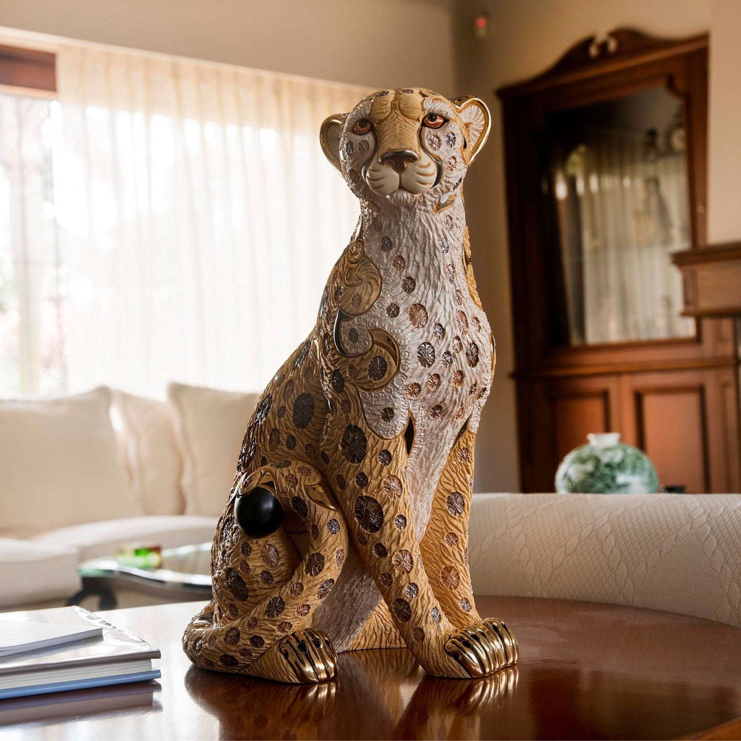 Handmade ceramic animal sculptures, specifically limited edition collectible wildlife figurines. Its materials and craftsmanship place it in the category of fine decorative ceramic art. Cheetah statue, luxury animal figurine, Uruguayan ceramic art, hand-painted ceramic cheetah, and gold-accented cheetah sculpture.