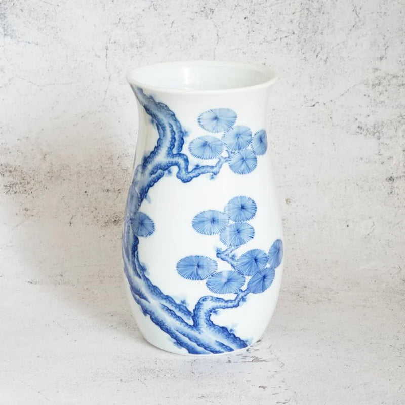 Mikawachi ware vase, Japanese porcelain vase, hand-painted pine tree vase, Hirado Shozan pottery, blue and white Japanese vase, pine tree motif vase, Nagasaki porcelain art, traditional Japanese pottery gift, Japanese wedding vase, Japanese anniversary gift, porcelain vase with pine design, symbolic Japanese home decor, luxury Japanese vase, seasonal Japanese vase, handcrafted Japanese porcelain, pine tree longevity symbol, Japanese cultural gift vase, artisan painted Japanese vase