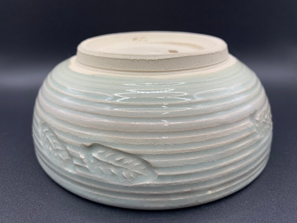 Japanese celadon pottery, handmade celadon tea bowl, ribbed ceramic tea bowl, carved leaf motif pottery, traditional Japanese ceramics, Longquan-style celadon ware, matcha chawan bowl, artisanal tea ceremony bowl, crackle glaze pottery, Song dynasty style ceramics, Japanese green glaze bowl, hand-thrown Japanese pottery, tea culture ceramics, Japanese chawan design, antique-style Japanese bowl, leaf pattern pottery, ribbed matcha bowl, celadon carving techniques, Japanese celadon glaze art, traditional Japa