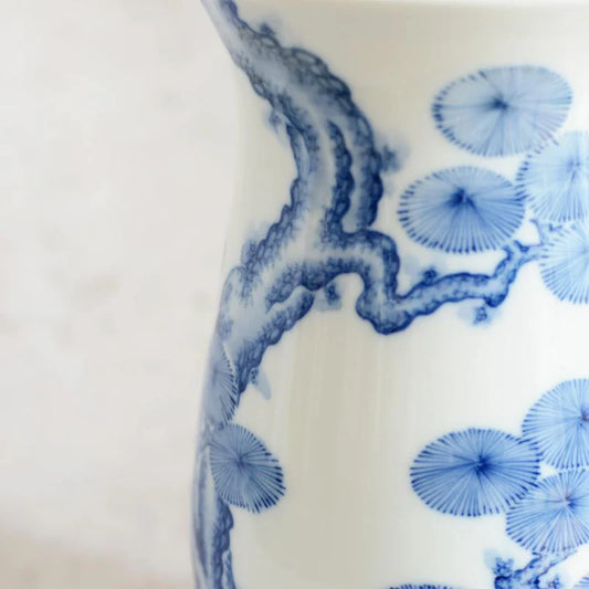 Mikawachi ware vase, Japanese porcelain vase, hand-painted pine tree vase, Hirado Shozan pottery, blue and white Japanese vase, pine tree motif vase, Nagasaki porcelain art, traditional Japanese pottery gift, Japanese wedding vase, Japanese anniversary gift, porcelain vase with pine design, symbolic Japanese home decor, luxury Japanese vase, seasonal Japanese vase, handcrafted Japanese porcelain, pine tree longevity symbol, Japanese cultural gift vase, artisan painted Japanese vase