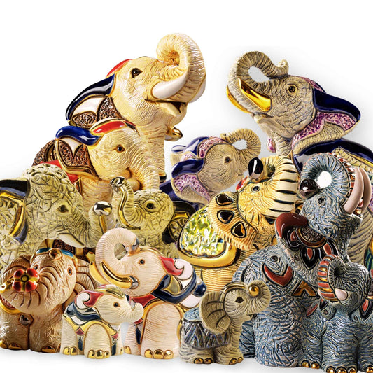 Handcrafted elephant figurines. Indian elephant ceramic statue. Sumatran elephant sculpture. Elephant decor with raised trunk. Gold and enamel elephant collectible. White elephant handmade statue. Mini elephant figurines for gifting. Artisan elephant sculptures from Uruguay. Elephant family figurine set. Elephant symbolism home decor. De Rosa elephant collection