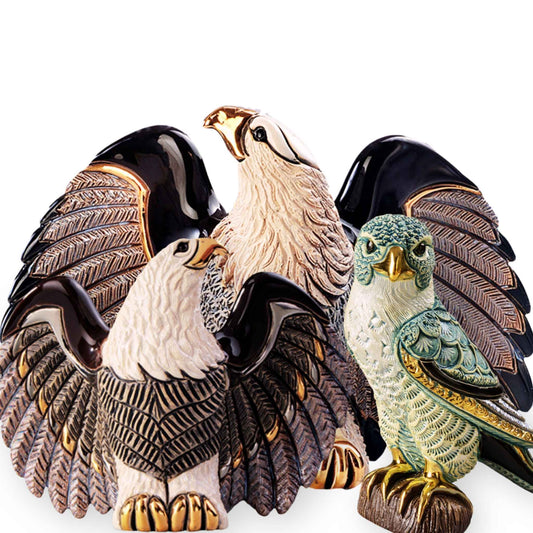 Bald eagle figurine handmade. Ceramic eagle and falcon statues. American eagle collectible sculpture. Artisan bird of prey figurines. Enamel falcon decor collectible. Gold-accented eagle ceramic statue. Handmade predator bird sculptures. Falcon bird figurine with perch. Bald eagle home decor ornament. Wildlife raptor figurine set