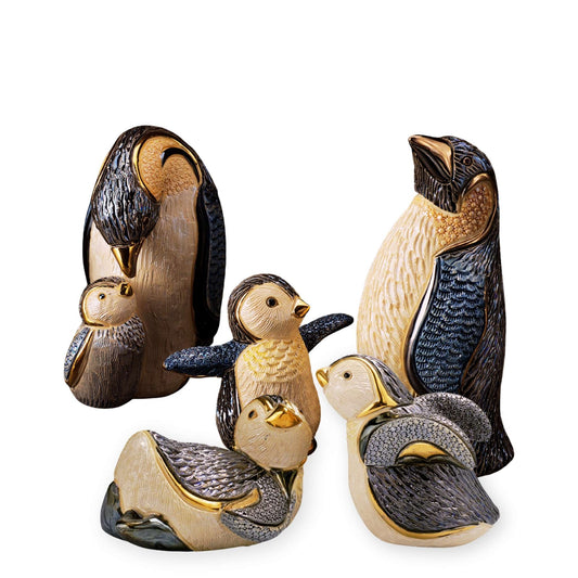 Handcrafted penguin figurines. Ceramic penguin family sculpture. Penguin baby and parent statue. Artisan animal figurines handmade. Penguin collectible set. Enamel and gold penguin statues. Antarctic wildlife home decor. De Rosa ceramic penguins. Sliding and walking penguin figurines. Symbolic penguin sculpture gift
